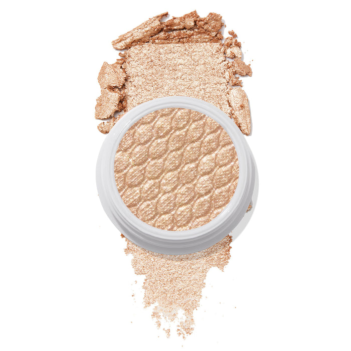 Flower Child ColourPop Super Shock Shadow swatched - soft champagne-gold shimmer eyeshadow in a white pot with quilted texture, crushed pigment smeared above and below on a white background to show its metallic cream-to-powder payoff.