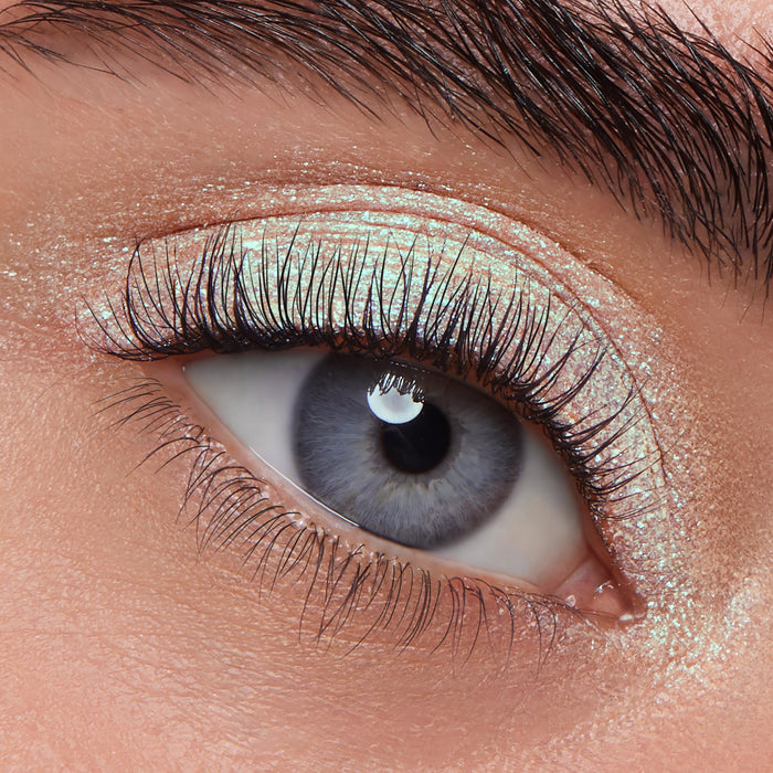 Shimmery sage-green sheen sweeps across the eyelid, showcasing the wet‑look, iridescent payoff of ColourPop Jelly Much Shadow Sage Bundle on a blue‑gray eye with curled lashes in a crisp studio macro close‑up.