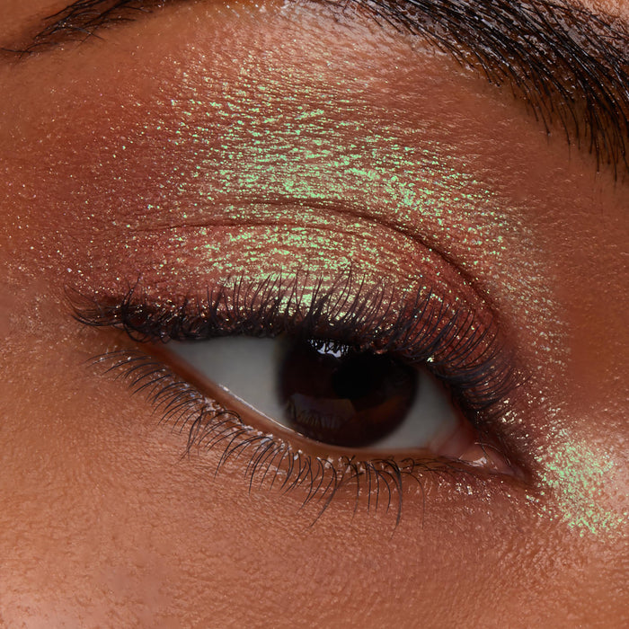 Closed eye wearing ColourPop Jelly Much Shadow in Shiny Penny, a copper metallic with green duochrome shimmer, coating the lid and crease in a smooth, foiled finish to showcase long-wear, high-shine payoff in a macro close-up.