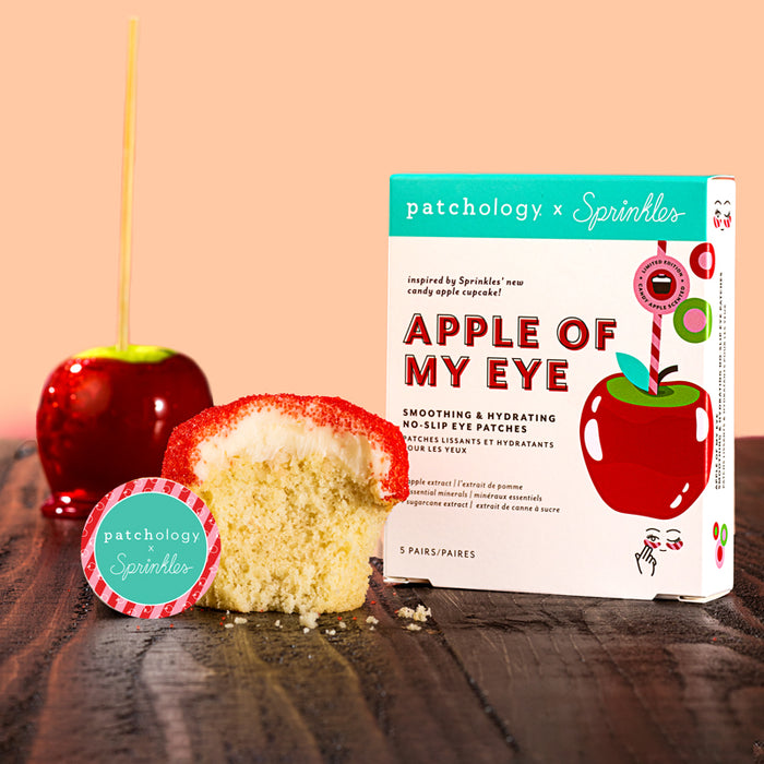 Patchology x Sprinkles Apple of My Eye eye patch packaging with a cupcake and red apple on a wooden surface.