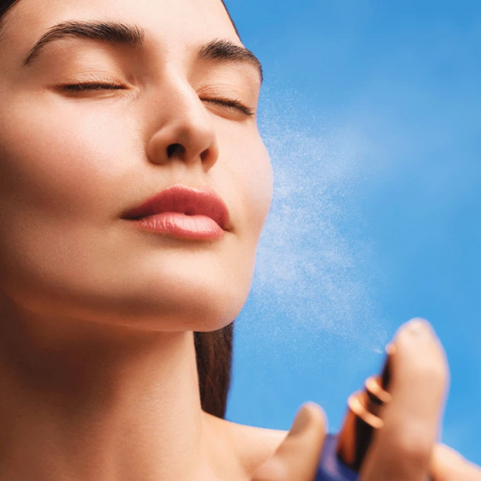 Woman applying Augustinus Bader The Face Mist for hydrating TFC8® skincare refresh