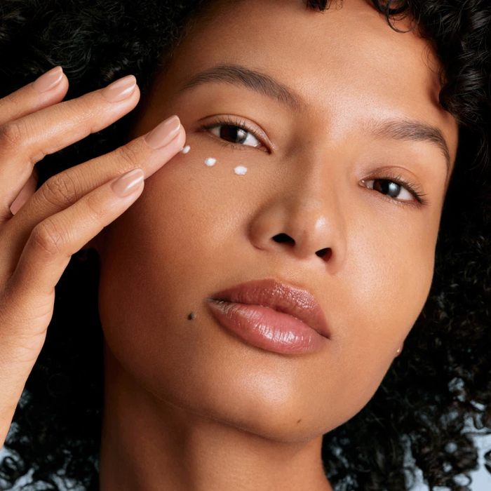 Woman applying Augustinus Bader The Rich Eye Cream under the eye