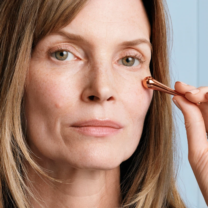 Woman applying Augustinus Bader The Rich Eye Cream to under-eye area with applicator