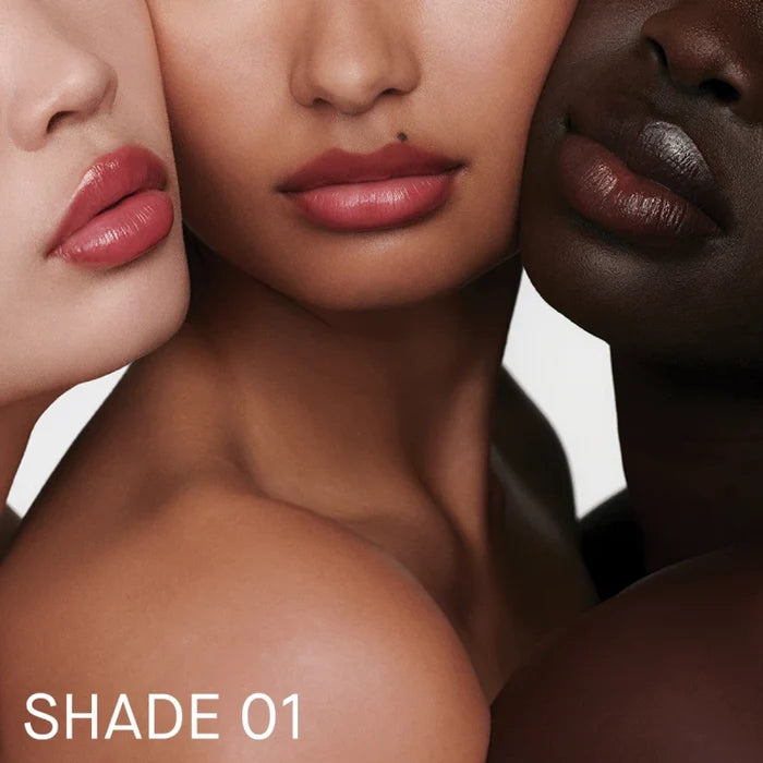 Three models wearing Augustinus Bader tinted balm shades, labeled Shade 01