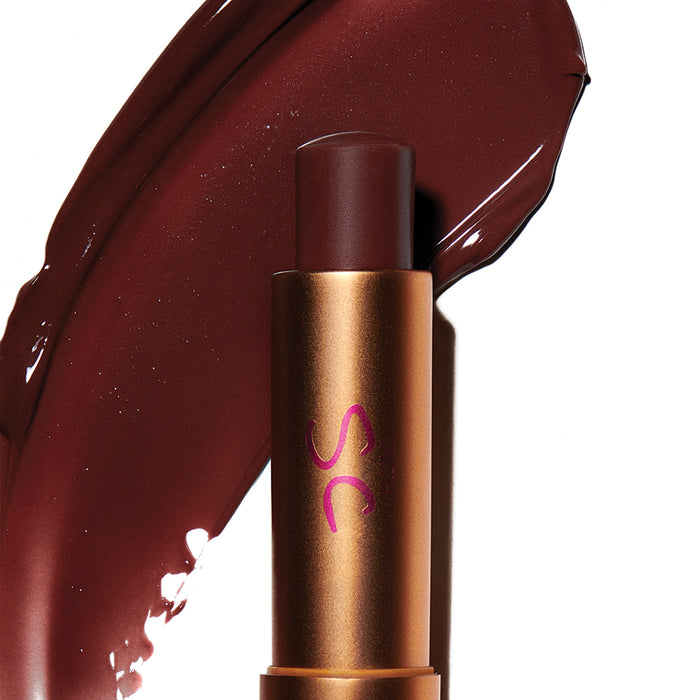 Augustinus Bader The Tinted Balm in deep berry shade with glossy lip color swatch