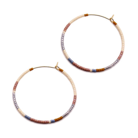 Gold-tone hoop earrings with neutral beaded cylinder accents, clasp backs visible
