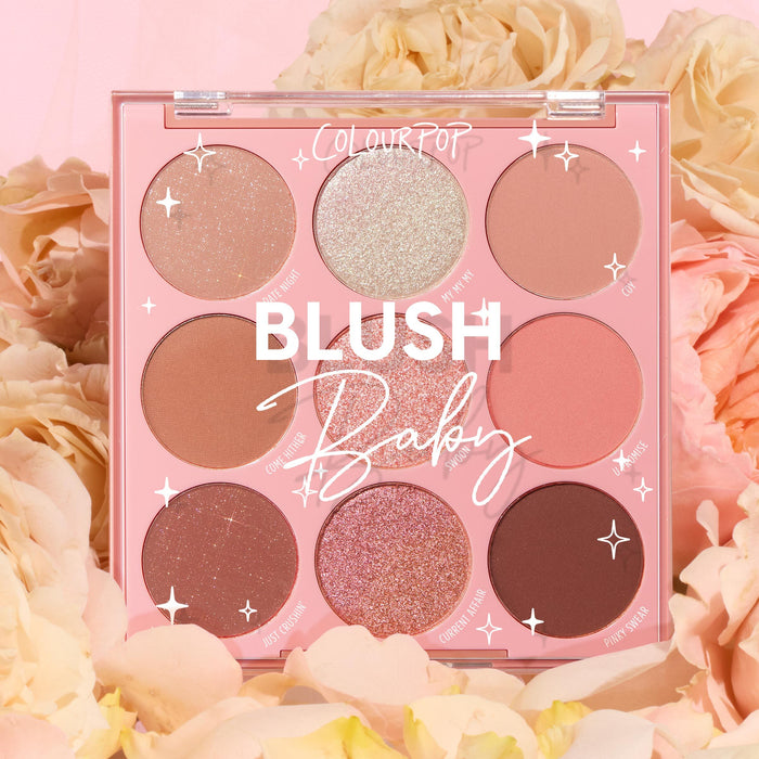 Blush Baby ColourPop Shadow Palette showcases nine pink and nude hues - matte, shimmer, and glitter - arranged in a pink compact, displayed open among soft cream and peach roses for a romantic spring makeup look.
