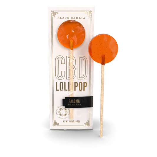 Paloma CBD lollipop, orange hard candy on a stick, shown with box