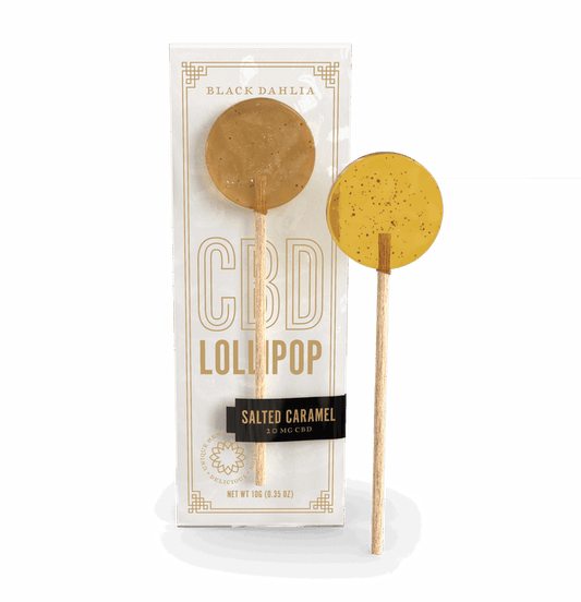 Salted caramel CBD lollipop with caramel-colored round candy on stick, in white box