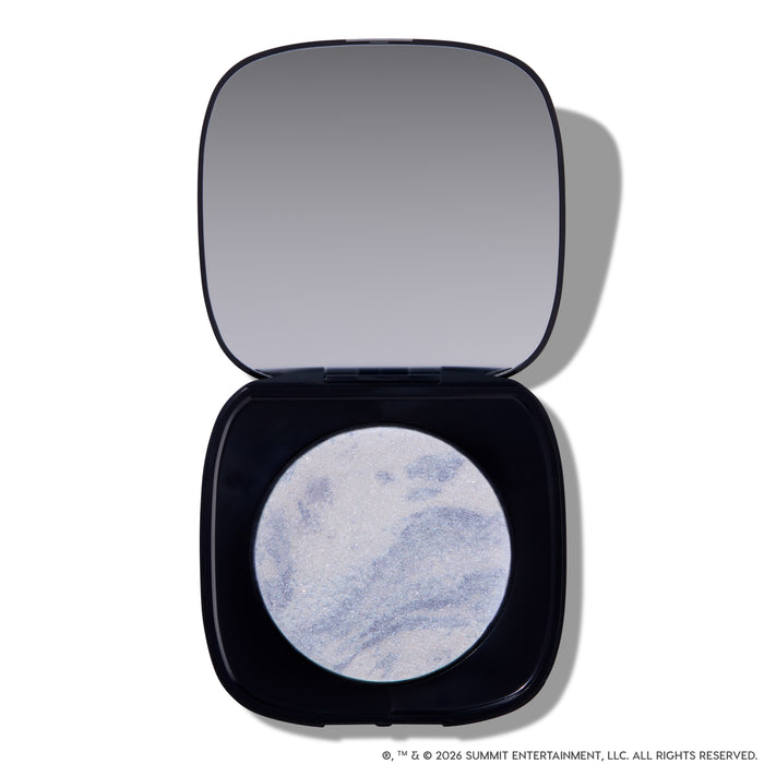 Open compact of Change Me Mega Highlighter with shimmering icy lavender and silver marbled pan set in a sleek black case with mirror, styled on a white background for the Twilight makeup collection.