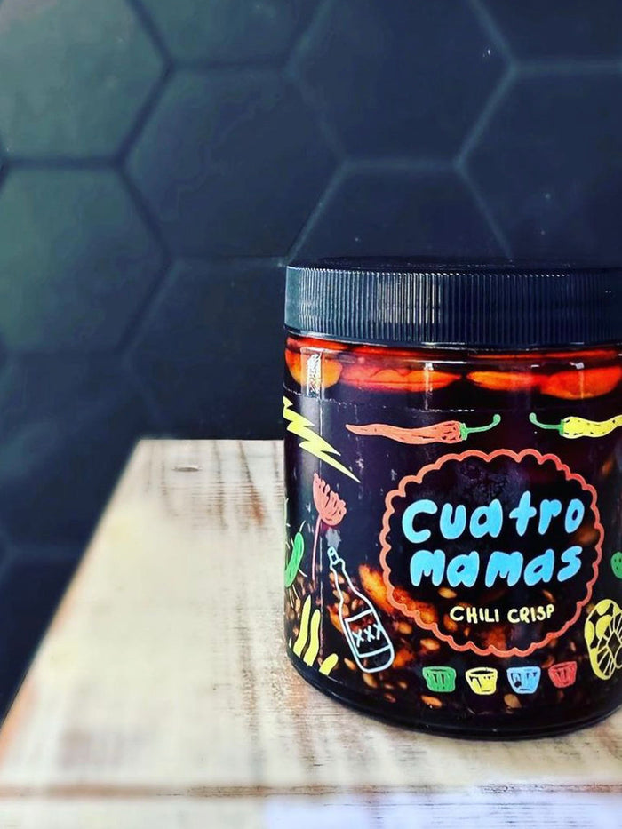 Chili crisp jar with Cuatro Mamas label and black lid