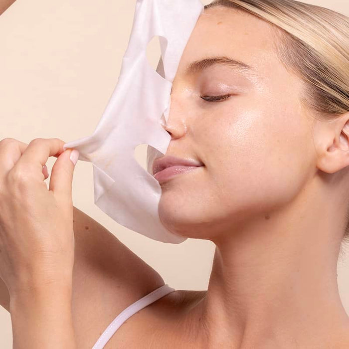 close up woman removing skin remedy sheet mask for sensitive skin