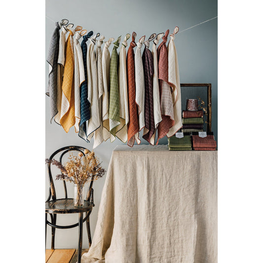 Double-weave dishtowels displayed on hooks, assorted neutral and warm colors.