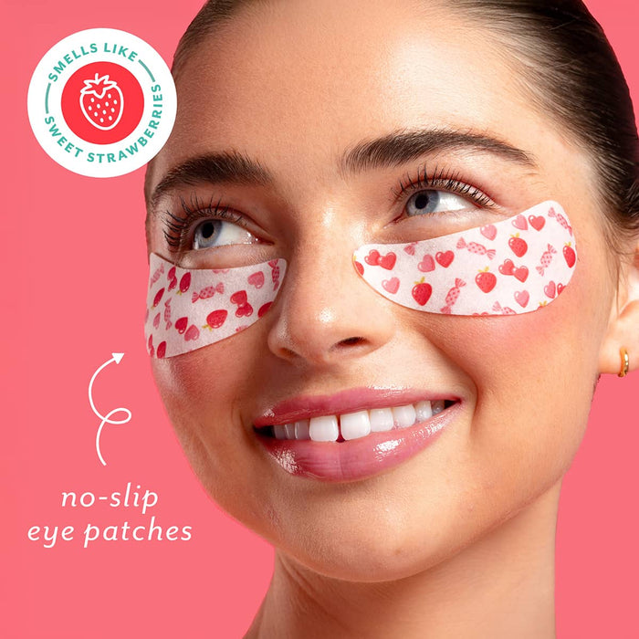 Woman wearing no-slip eye patches with a strawberry-themed label on a pink background