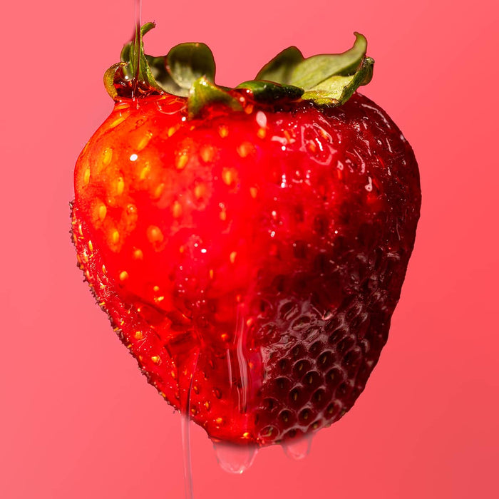 Strawberry with water droplets on a pink background
