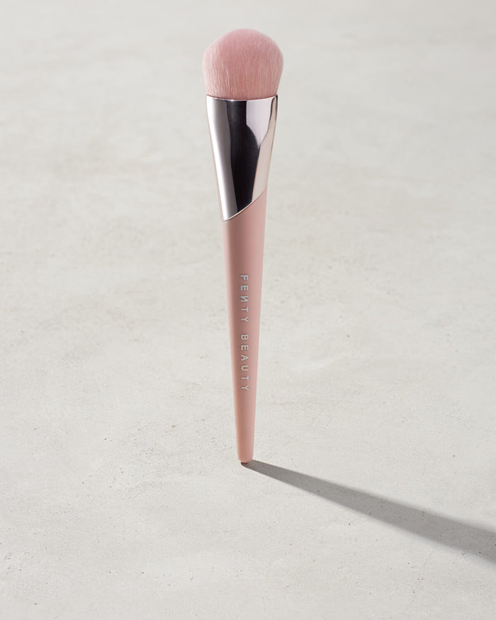 Full-Bodied Foundation Brush 110 standing upright on a concrete backdrop.