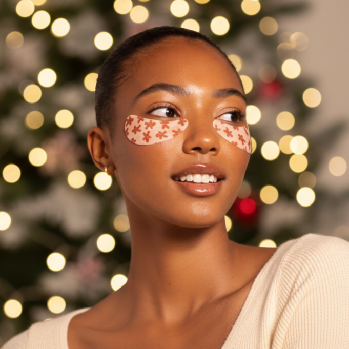 Woman with decorative face paint in front of a Christmas tree