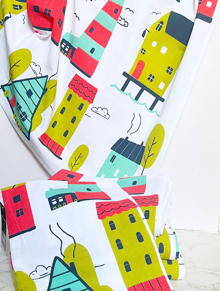 Illustrated abstract homes design on The Coin Laundry kitchen towel featuring colorful house illustrations.