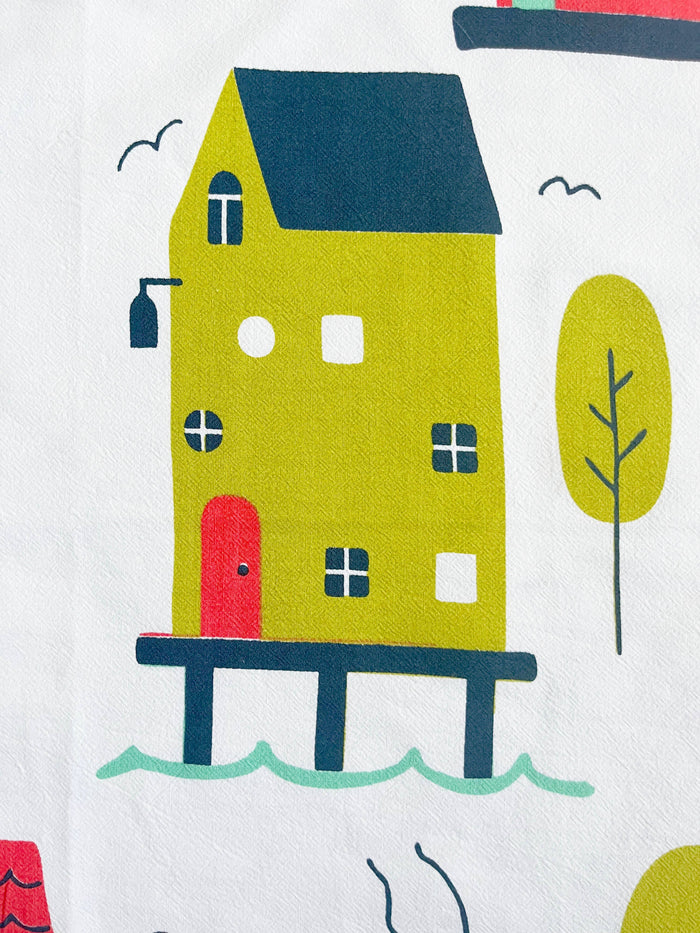 Illustrated abstract homes pattern on The Coin Laundry kitchen towel featuring colorful house illustrations.