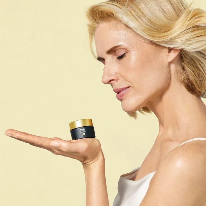 ISDIN Isdinceutics Vital Eyes eye cream jar on open palm beside model face