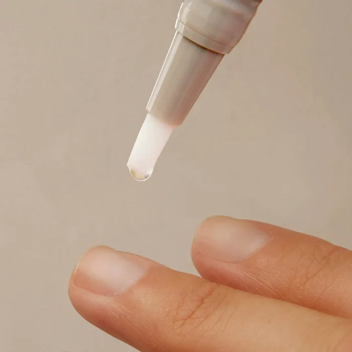 ISDIN Si-Nails serum applicator dropping nail strengthening treatment onto fingernails
