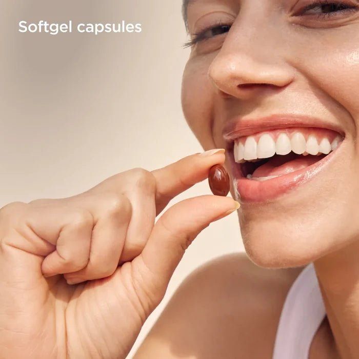 Woman holding a brown softgel capsule for ISDIN SUNISDIN antioxidant supplement