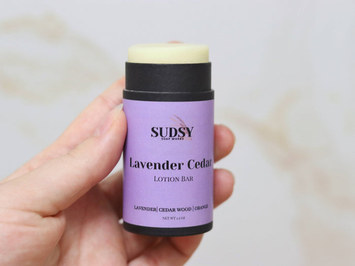 Lavender and cedar scented lotion bar from Sudsy Soap Works LLC, showing a natural solid moisturizer with lavender and cedar accents.