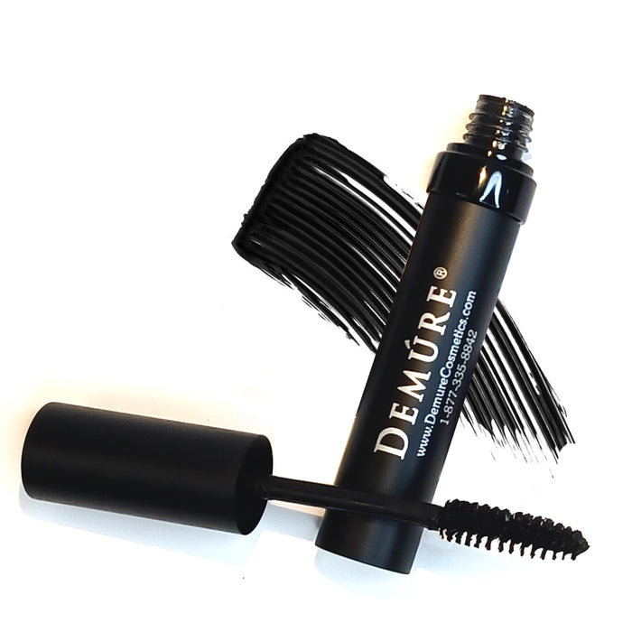 An open tube of Demure Black Mascara showing the applicator and a swatch of mascara.