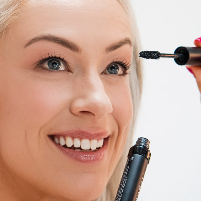 Woman applying Demure High Def Black Mascara