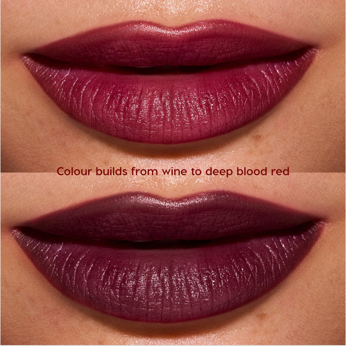 Close-up lips wearing Newborn powder to creme lipstick from the Twilight collection, showing buildable color shifting from rich wine to deep blood-red with a smooth, satin finish on medium skin tone.
