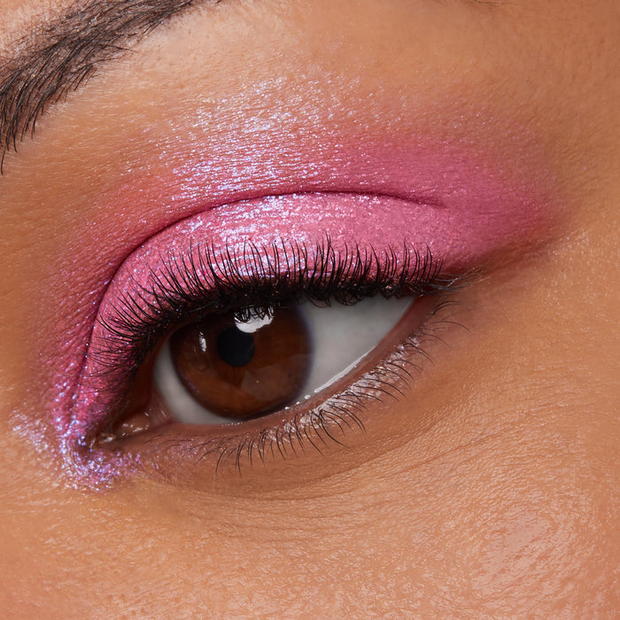 Shimmering hot-pink lid on an open brown eye showcases the wet-metallic payoff of ColourPop Jelly Much Shadow, No Rest For The Vivid, with fine sparkle and an inner-corner highlight in a tight macro of lashes and smooth skin.