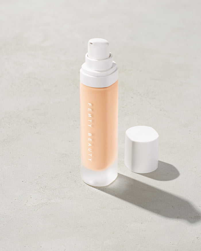 open bottle of Fenty Beauty Pro Filt'r Soft Matte Longwear Foundation with pump dispenser in shade #110 on concrete background
