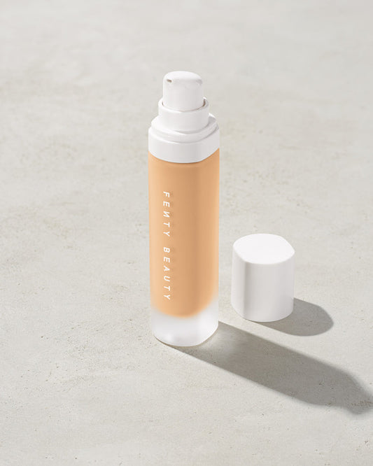 open bottle of Fenty Beauty Pro Filt'r Soft Matte Longwear Foundation with pump dispenser in shade #210 on concrete background