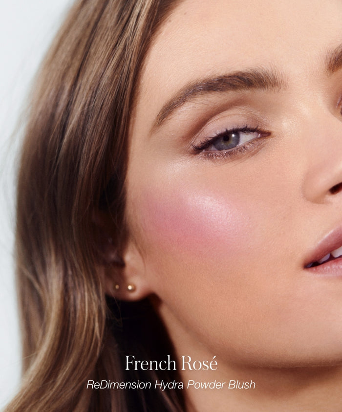 Close-up of a woman’s face wearing French Rosé ReDimension Hydra Powder Blush, showcasing a natural pink blush look as part of the RMS Discovery Kit makeup collection.