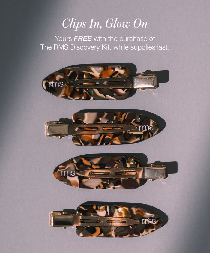 Four tortoiseshell patterned hair clips with gold clips laid out on a flat surface promoting a free gift with the purchase of the RMS Discovery Kit while supplies last.