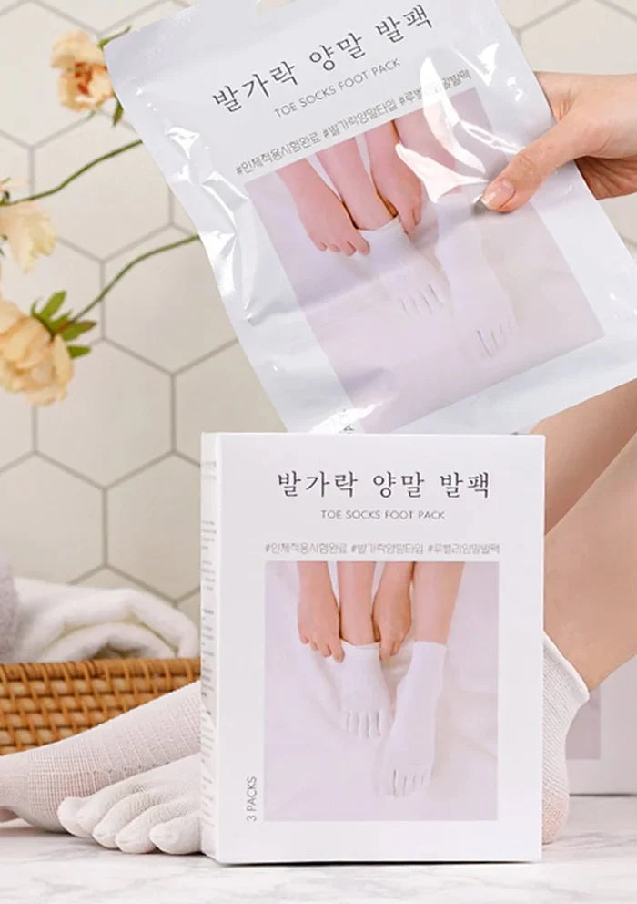 Toe socks foot pack packaging with a person wearing them on a tiled bathroom floor.
