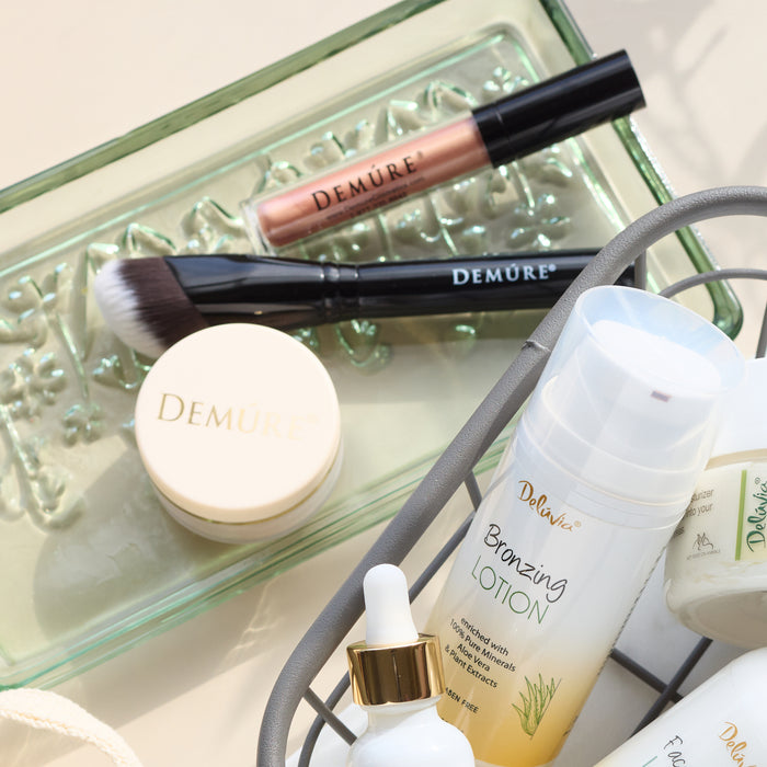 A glass makeup tray with Demure blush, Crystal Pink lip gloss and a Sculpting Contour Brush