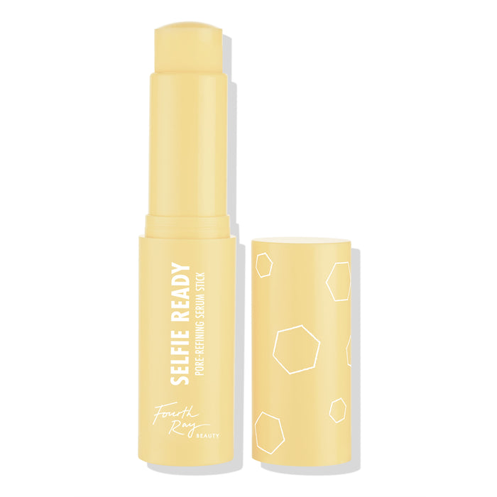 Selfie Ready pore-refining serum stick by Fourth Ray Beauty stands uncapped, revealing a rounded balm tip; pale yellow twist-up tube with white hexagon graphics and matching cap set beside it on a white background, ColourPop Serum Stick.