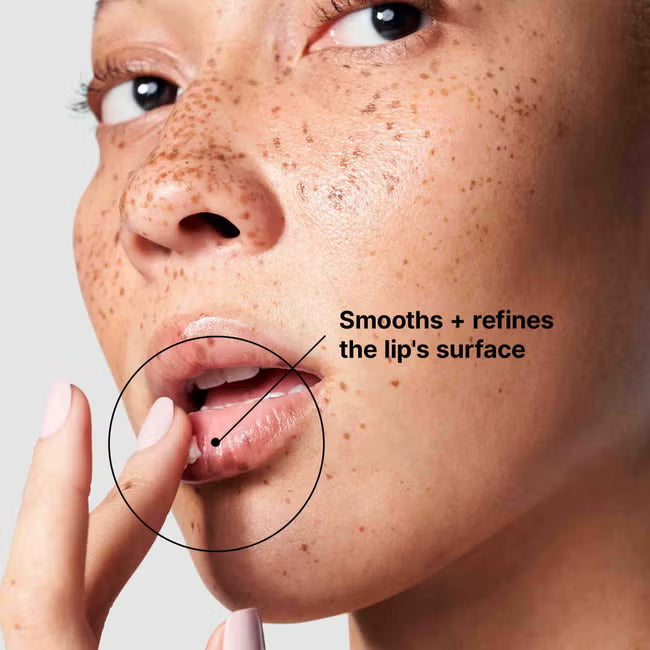 Woman applying lip treatment with text “Smooths + refines the lip’s surface”