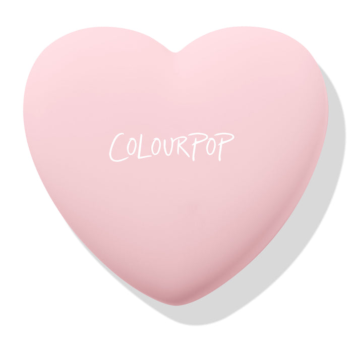 Sweetheart ColourPop Pressed Powder Blush compact rests closed, showing the COLOURPOP logo on a pastel pink heart-shaped case against a white background with a soft shadow.