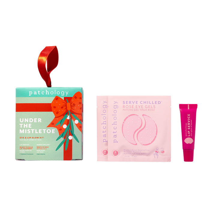Skincare holiday kit with two pink eye masks and a tube of Lip Service gloss on a white background.